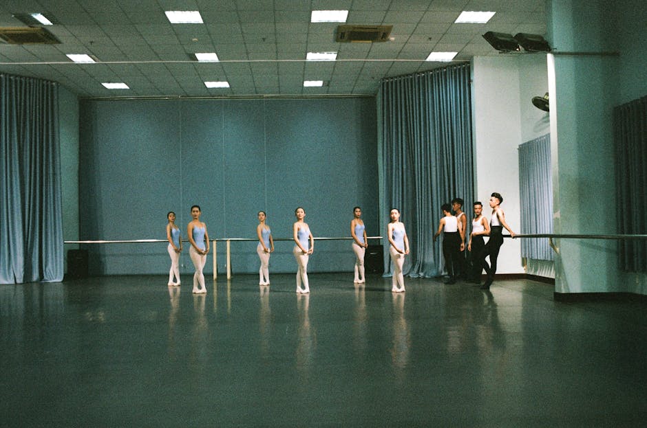 Group of young ballet students practicing in a spacious, well-lit studio.