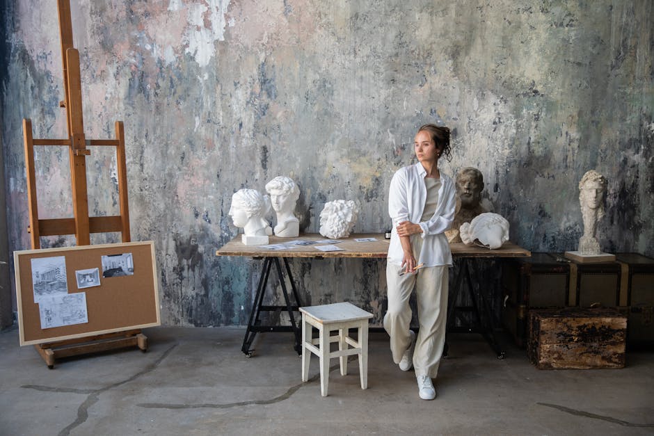 A creative workspace showing an artist among sculptures in a rustic art studio.